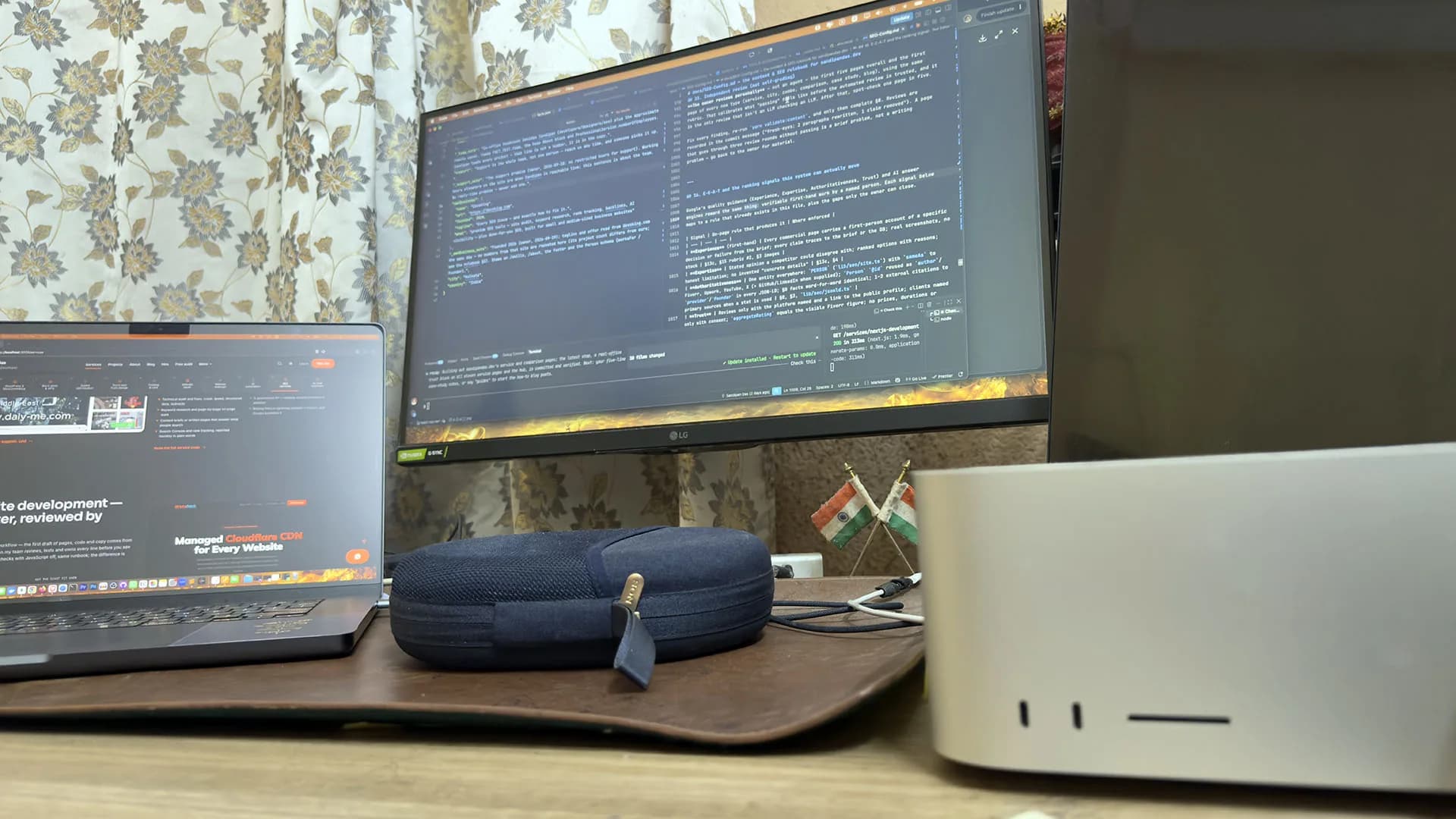 Sandipan Das's home desk: a laptop with the site open, a monitor showing code, a Mac Studio and two small Indian flags
