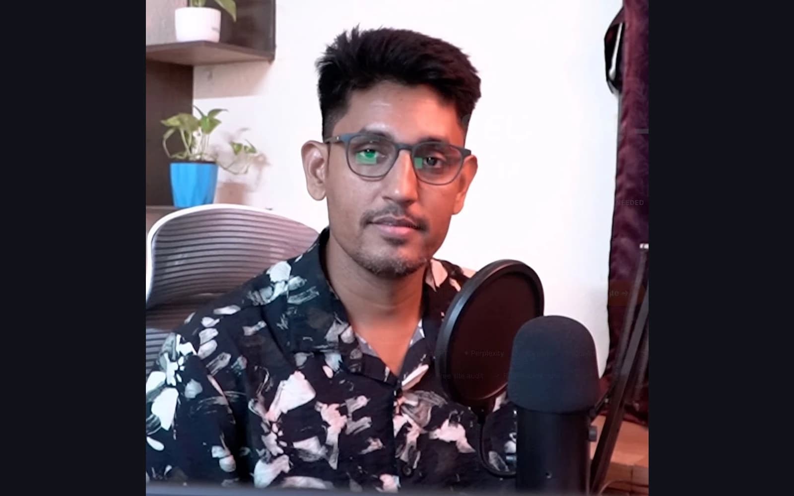 Sandipan Das speaking into the microphone at the office desk, Kolkata, India
